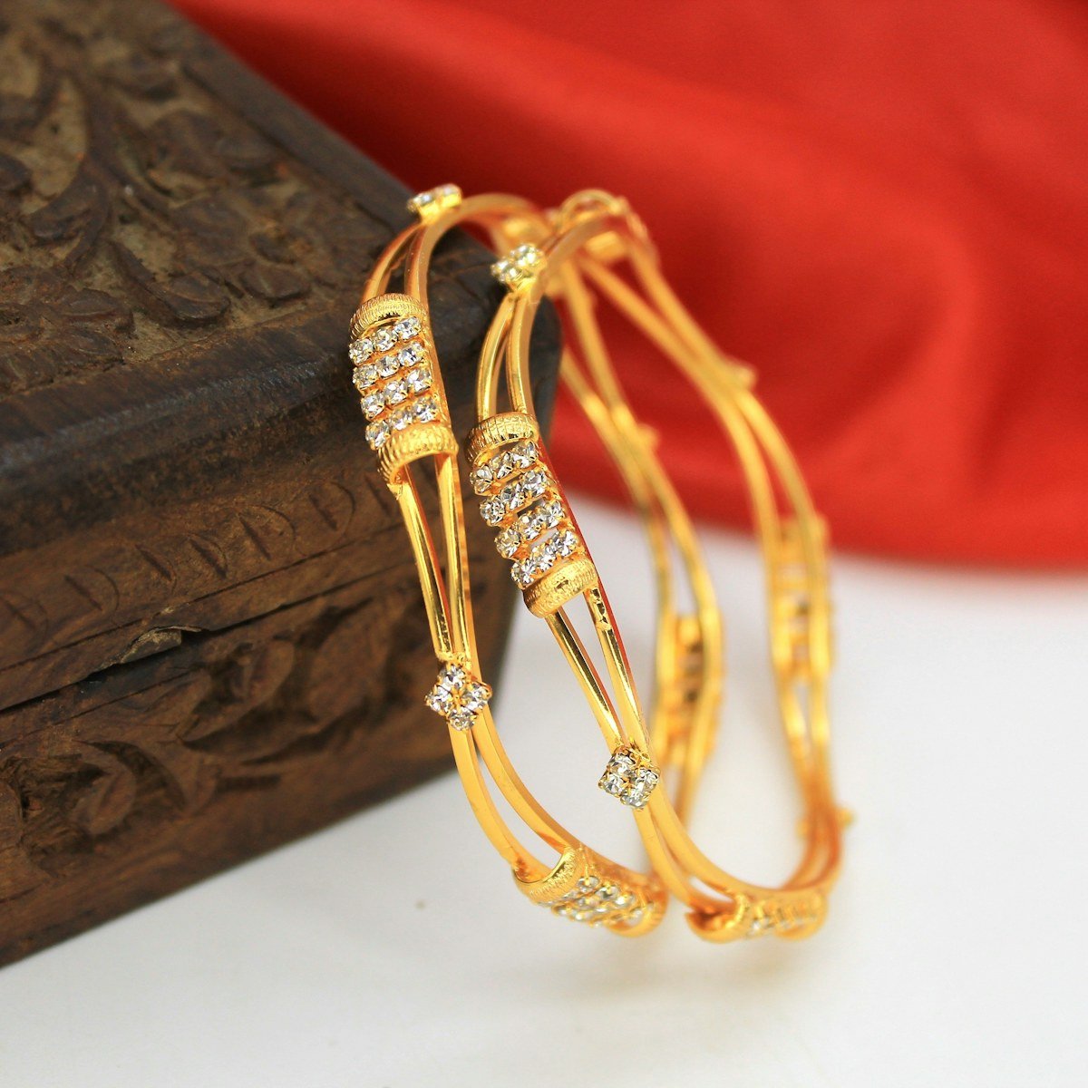 Pair of gold bangles on a wooden box