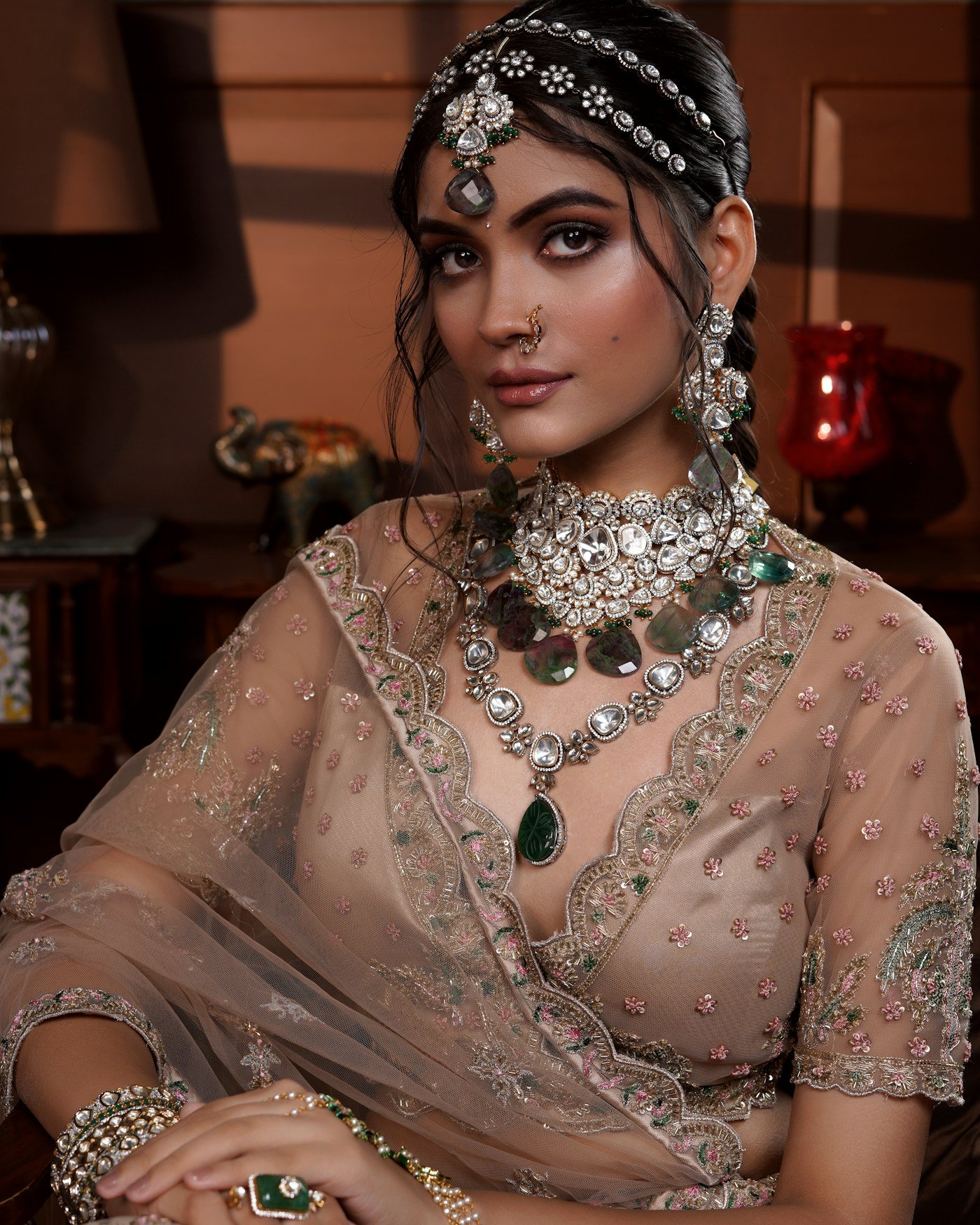 Bride wearing a polki choker, matha patti and emerald drop earrings